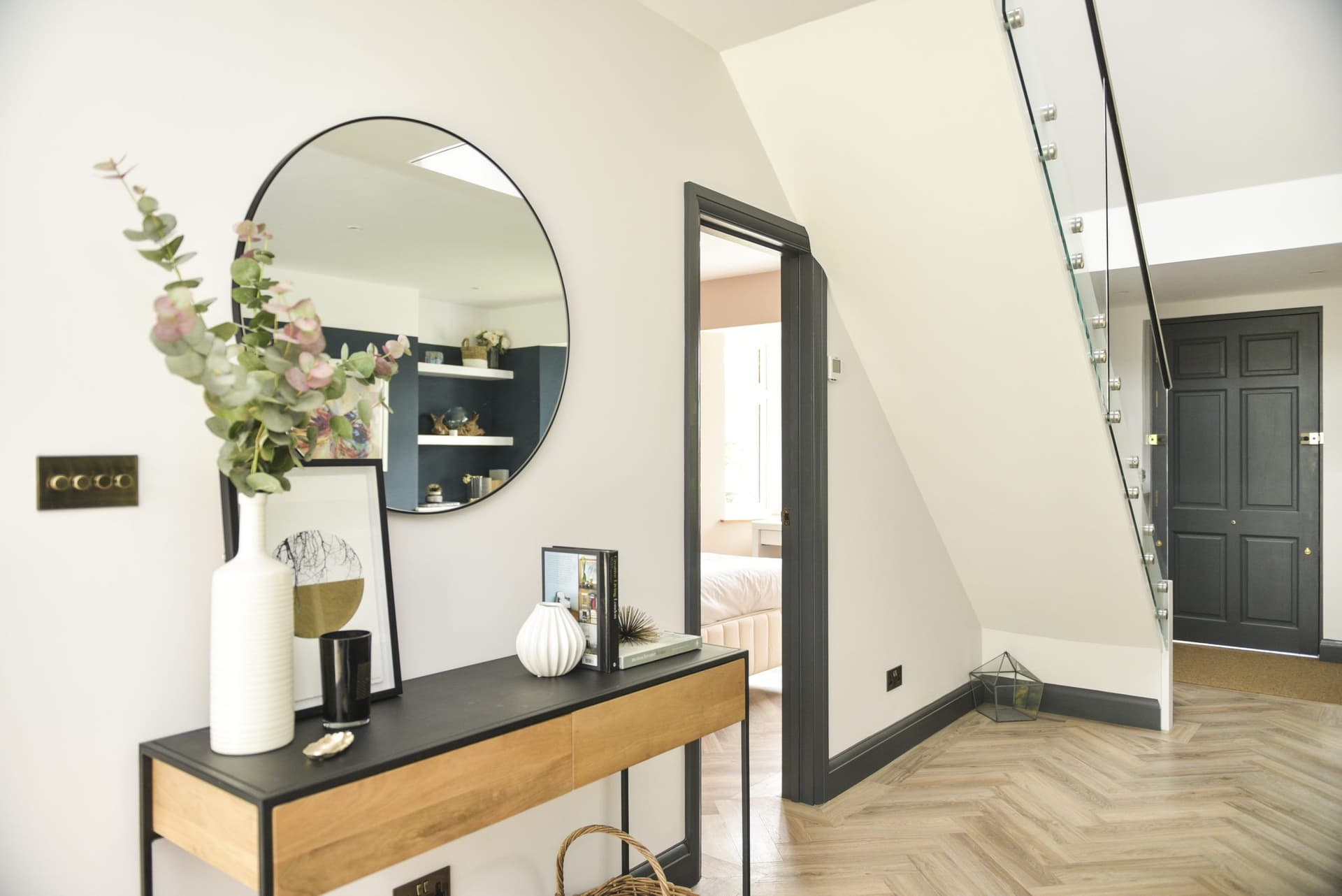 Hallway with herringbone floor and glass balustrade