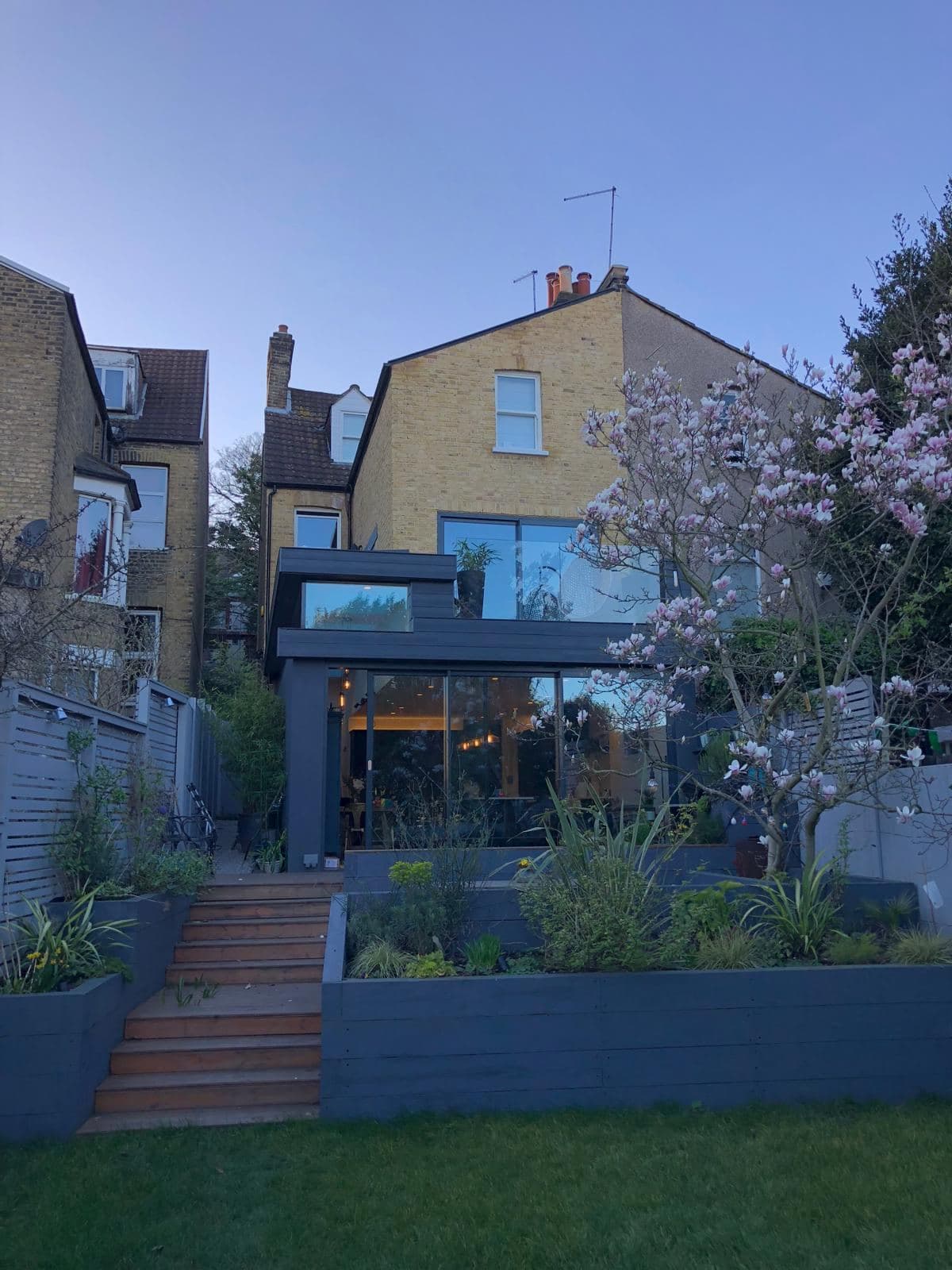 Rear of the Westcombe Hill house after the extension, glazed corner and garden